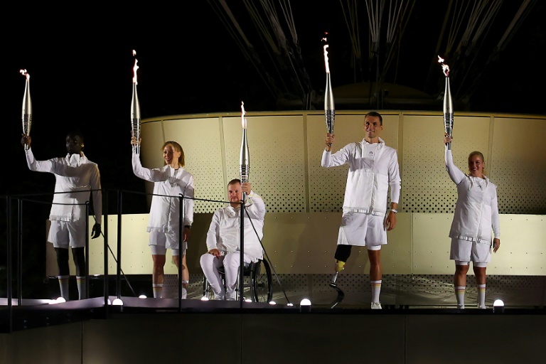 Le pongiste Fabien Lamirault (3e en partant de la gauche) avant d'allumer le chaudron des Jeux paralympiques, le 28 août 2024 à Paris