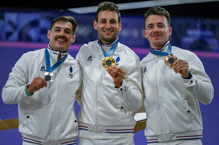 Le médaillé d'or français de BMX Racing Joris Daudet (au centre), avec le médaillé d'argent Sylvain André (à gauche) et le médaillé de bronze Romain Mahieu (à droite) lors des Jeux olympiques de Paris à Saint-Quentin-en-Yvelines, le 2 août 2024