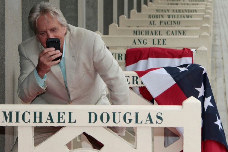 L'acteur américain Michael Douglas photographie son nom sur les Planches à Deauville, dans le Calvados, le 31 août 2013