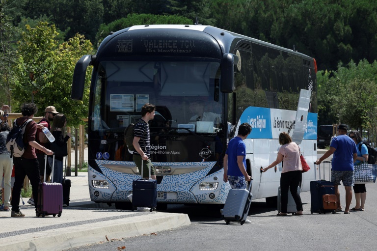 Des voyageurs montent dans un bus à l'arrêt de la région Auvergne-Rhône-Alpes à Vallon-Pont-d'Arc, le 15 août 2024 en Ardèche