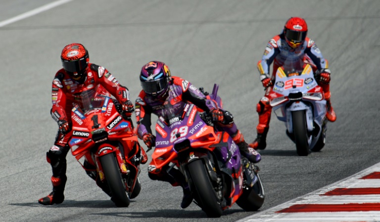 Le pilote italien Francesco Bagnaia (Ducati, à gauche), l'Espagnol Jorge Martin (Ducati-Pramac, à droite) et son compatriote Marc Marquez (Ducati-Gresini à l'arrière-plan) lors de la course sprint du Grand Prix d'Autriche MotoGP sur le circuit de Spielberg le 17 août 2024.