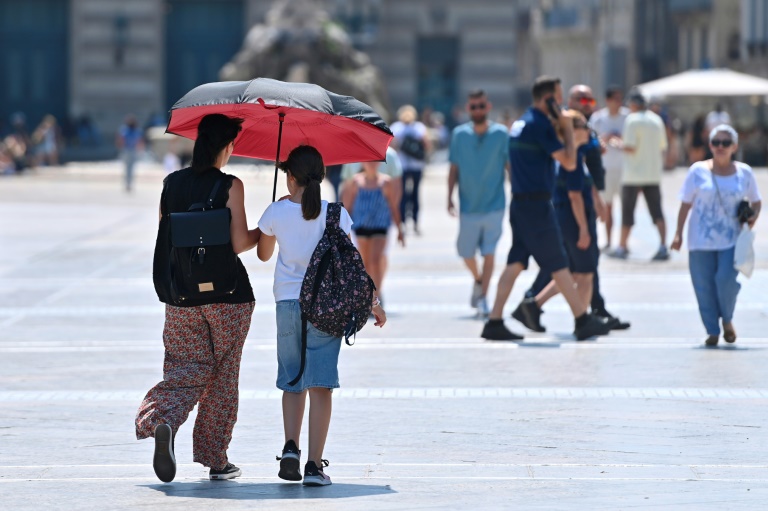 Des habitants se protègent du soleil à Montpellier, le 19 juillet 2024