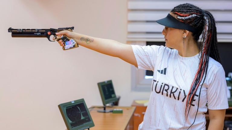 Sevval Ilayda Tarhan tire aussi la main dans la poche, portant une casquette comme seul accessoire