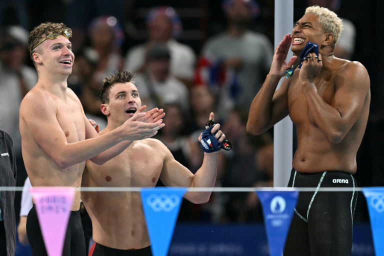 Leon Marchand au côté de Maxime Grousset et Yohann Ndoye-Brouard après la finale du relais 4x100m quatre nages aux Jeux de Paris