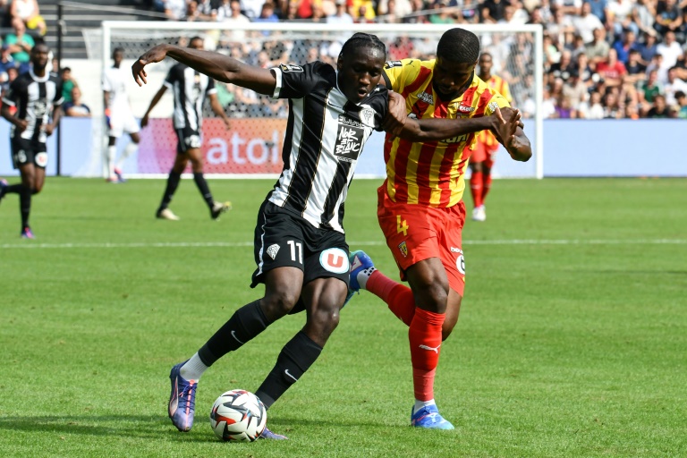 Le joueur d'Angers Sidiki Cherif (à gauche) à la lutte avec celui de Lens Kevin Danso Wesley Said (à droite) lors du match de la première journée du championnat de France de L1 au stade Raymond-Kopa à Angers le 18 août 2024.