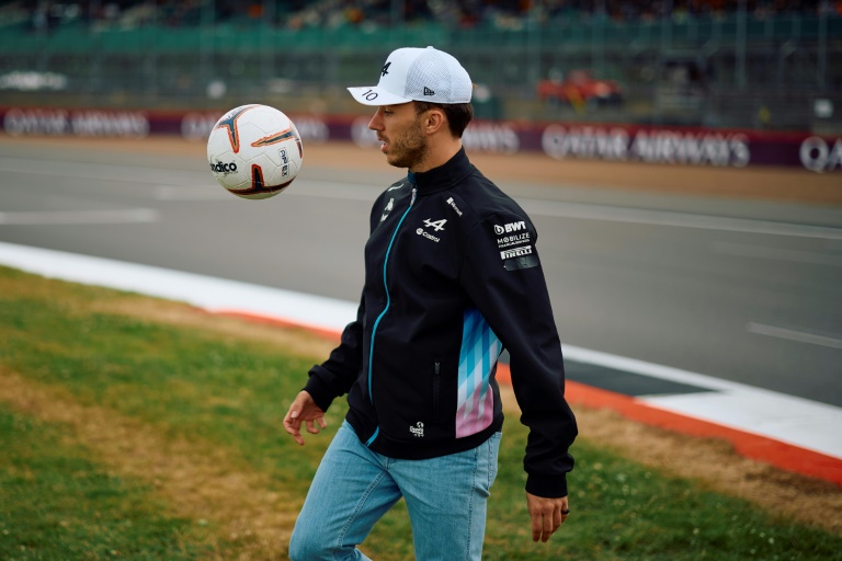 Le pilote français de Formule 1 Pierre Gasly joue avec un ballon de football en marge du Grand-Prix de Grande-Bretagne sur le circuit de Silverstone le 4 juillet 2024.