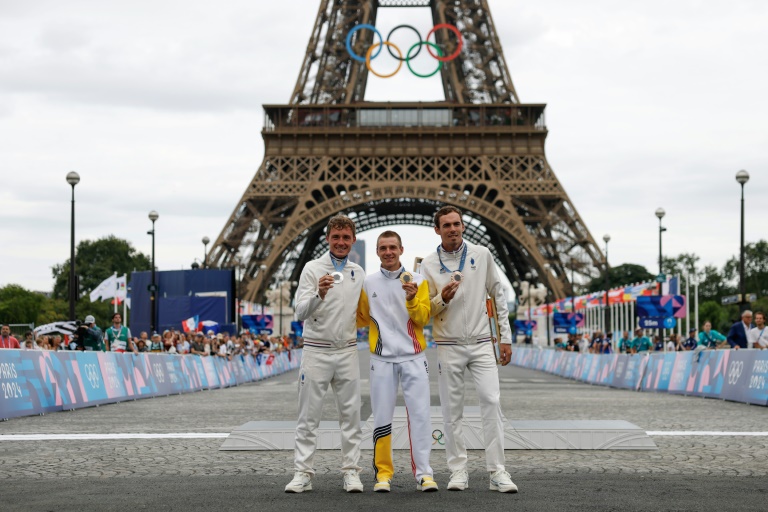 Le médaillé d'argent Valentin Madouas (G)a côté du médaillé d'or Remco Evenepoel et du médaillé de bronze Christophe Laporte lors de la cérémonie des médailles après la course en ligne des Jeux olympiques de Paris, à Paris, le 3 août 2024