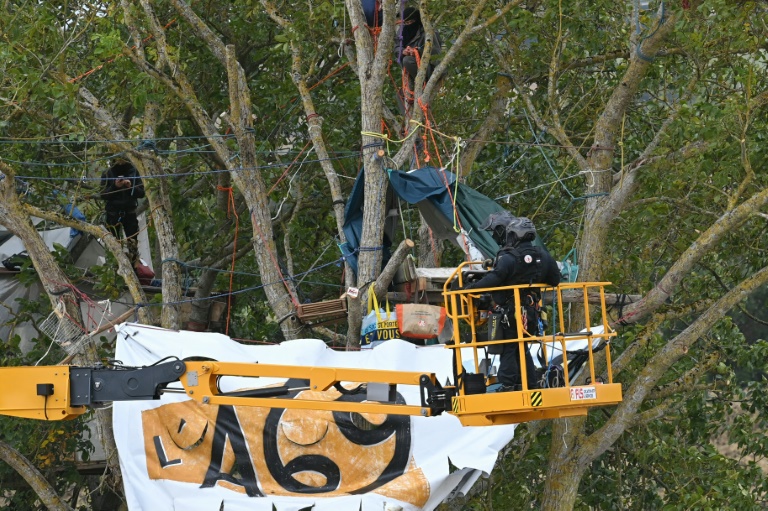 Les gendarmes dégagent une bannière des opposants à l'A69 installés dans un arbre, le 27 septembre 2024, à Verfeil, en Haute-Garonne