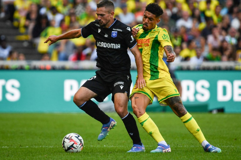 Le milieu de terrain français d'Auxerre Gaëtan Perrin (g.) à la lutte avec le milieu de terrain brésilien de Nantes Douglas Augusto (d.) pendant le match de L1 entre le FC Nantes et l'AJ Auxerre, à Nantes, le 25 août 2024