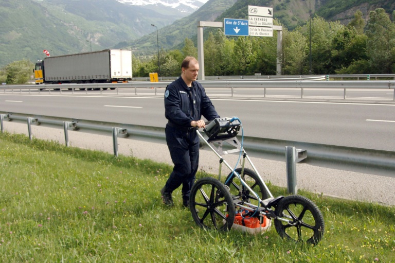 Un expert de l'Institut de recherche criminelle de la gendarmerie nationale (IRCGN) scanne le sol à l'aide d'un appareil géodésique, le 27 mai 2008 à Sainte-Marie-de-Cuines sur l'A43