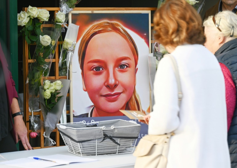 Des habitantes déposent des messages et des fleurs devant un portrait de Lola dont le corps a été retrouvé dans une malle, le 21 octobre 2022 à Paris