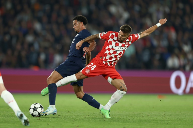 Le Parisien Warren Zaïre-Emery (g) à la lutte avec l'attaquant de Gérone Christian Portu, le 18 septembre 2024 au Parc des Princes