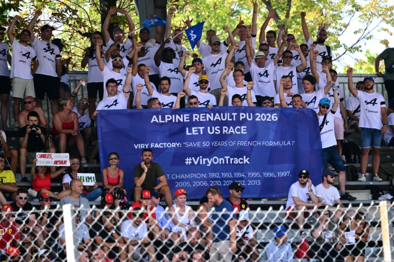 Des employés d'Alpine manifestent le 30 août 2024 lors des essais libres du Grand Prix d'Italie sur le circuit de Monza pour défendre la production de moteurs de F1 en France, sur le site de Viry-Châtillon, au sud de Paris