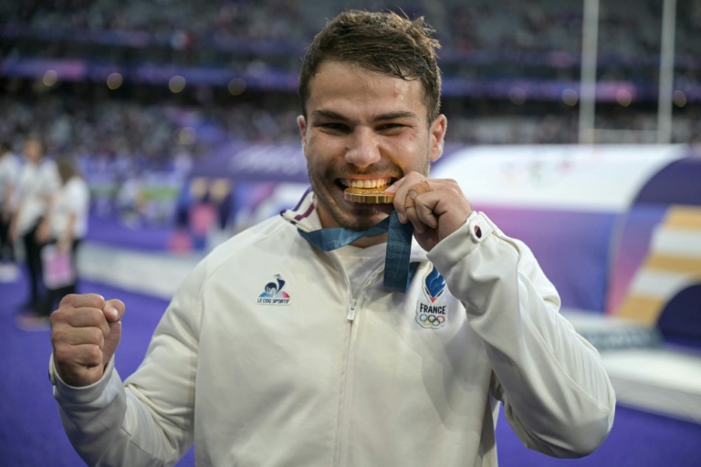 Le Français Antoine Dupont célèbre sa médaille d'or lors de la cérémonie qui suit le match de rugby à VII entre la France et les Fidji, lors des Jeux olympiques de Paris 2024 au Stade de France à Saint-Denis, le 27 juillet 2024