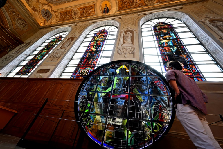 Un visiteur regarde les vitraux imaginés en 1935 par 12 artistes maîtres verriers pour la cathédrale Notre-Dame de Paris et exposés à la Cité du Vitrail, à Troyes, le 18 septembre 2024