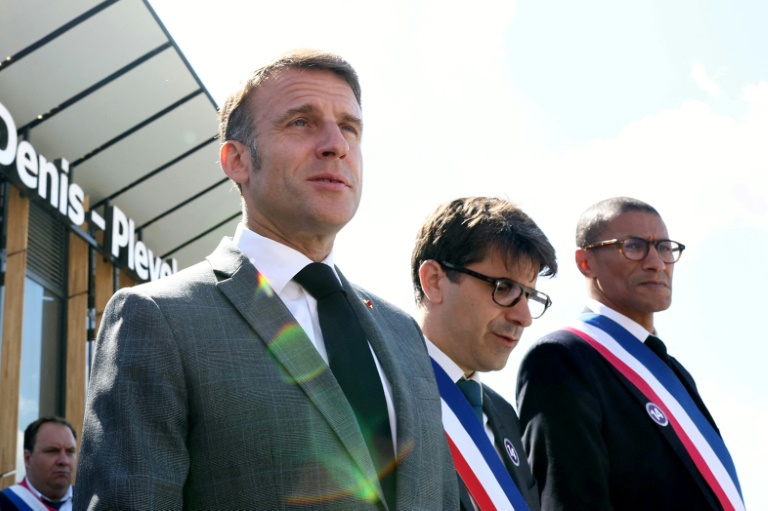 Emmanuel Macron, le maire de Saint-Denis Mathieu Hanotin (C) et le maire de Saint-Ouen Karim Bouamrane (D), le 24 mai 2024 au nord de Paris