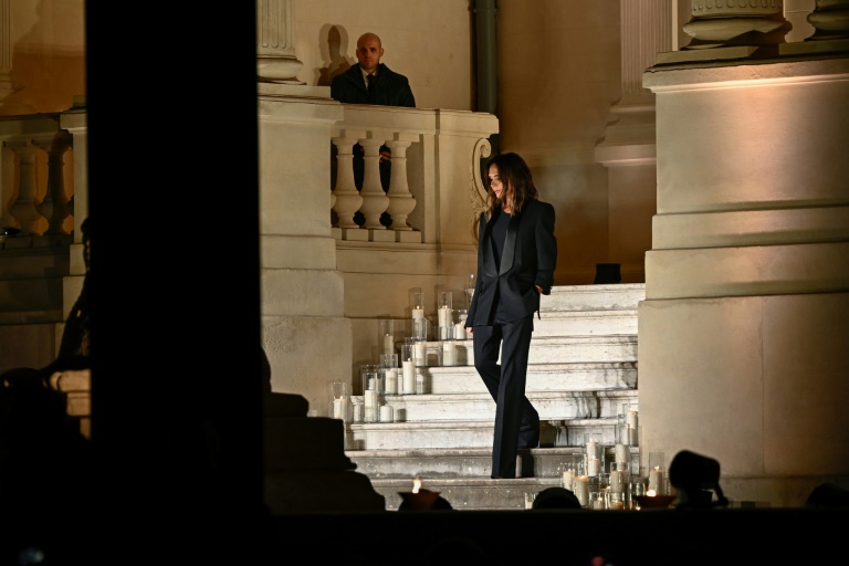 La styliste britannique Victoria Beckham salue le public à l'issue de son défilé pour la pour la collection de prêt-à-porter féminin printemps-été 2025 dans le cadre de la semaine de la mode de Paris, à Paris le 27 septembre 2024