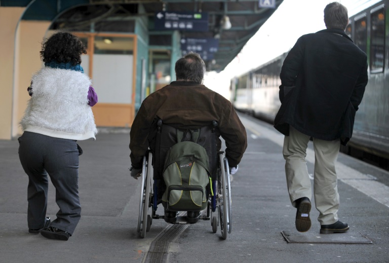 Trois personnes à mobilité réduite lors de l'inauguration de la première voiture adaptée au voyage de personnes, à la gare de Caen le 31 mars 2010