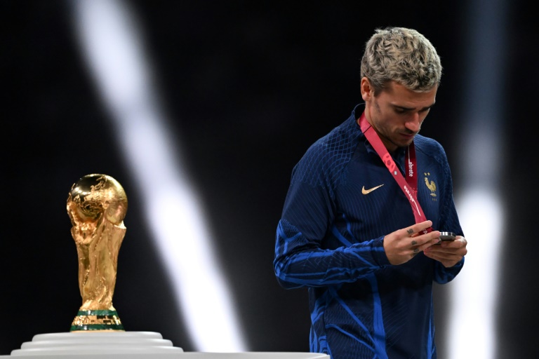 Le vice-capitaine de l'équipe de France Antoine Griezmann passe devant le trophée de la Coupe du monde à l'issue de la finale perdue contre l'Argentine le 18 décembre 2022 à Lusail au Qatar