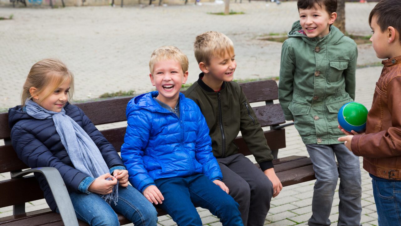 Un groupe d'enfants est assis sur un banc et s'amusent ensemble, dans la joie et la bonne humeur