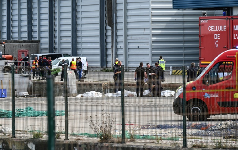 Des pompiers sont rassemblés autour des dépouilles de migrants morts dans le naufrage de leur embarcation, lors d'une tentative de traversée de la Manche le 3 septembre 2024