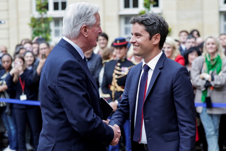 Michel Barnier sert la main du Premier ministre sortant Gabriel Attal lors de la cérémonie de passation de pouvoir à l'Hotel Matignon à Paris, le 5 septembre 2024