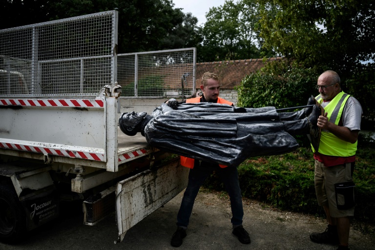 Des employés municipaux chargent dans un camion sur une statue de l'abbé Pierre après l'avoir déboulonnée, à Norges-la-Ville, le 17 septembre 2024