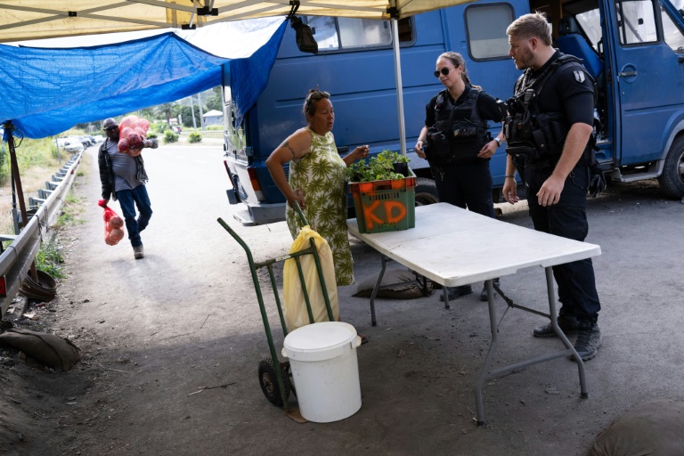 Des gendarmes contrôlent une habitante à un barrage routier à Saint-Louis, au sud de Nouméa, le 23 septembre 2024 en Nouvelle-Calédonie