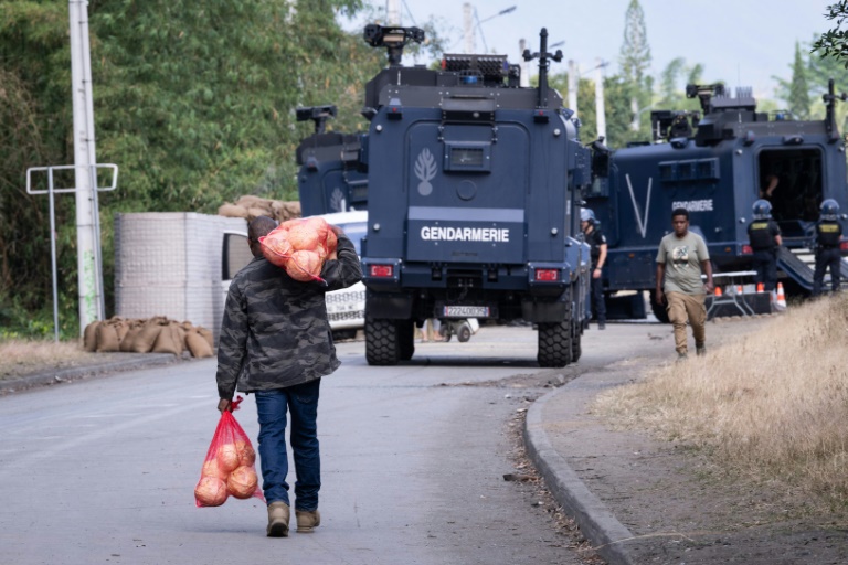 Un homme transporte des vivre près d'un barrage de la gendarmerie, à Saint-Louis, en Nouvelle-Calédonie, le 23 septembre 2024