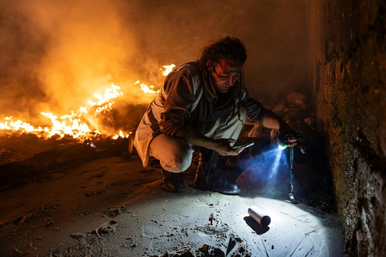 photographie des cartouches de gaz lacrymogène près d'un canot en feu sur la plage du Portel (Pas-de-Calais) le 21 septembre 2024