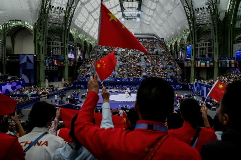 Des supporters chinois encouragent leurs sportifs lors d'un combat de taekwondo pendant les Jeux olympiques 2024, au Grand Palais à Paris, le 9 août 2024