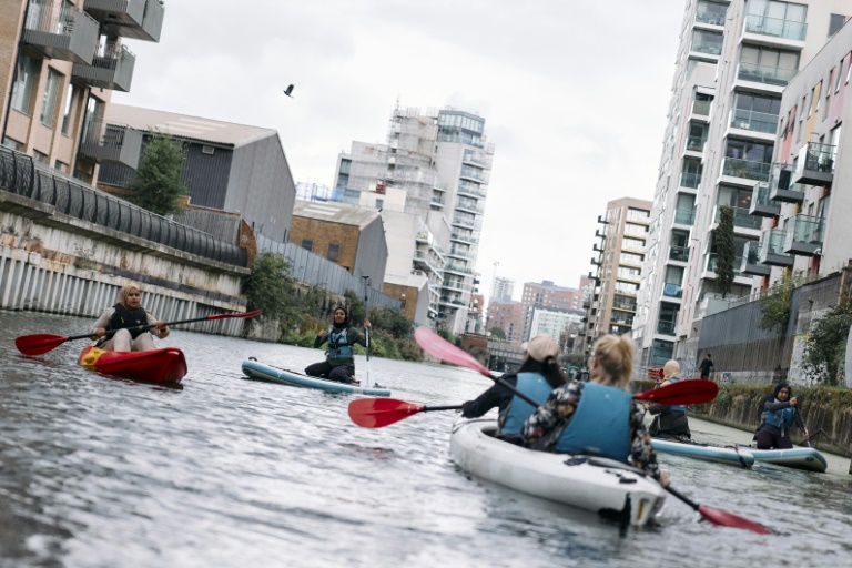 Plusieurs femmes participent à un cours de kayak et paddle sur un canal de l'est de Londres en septembre 2024