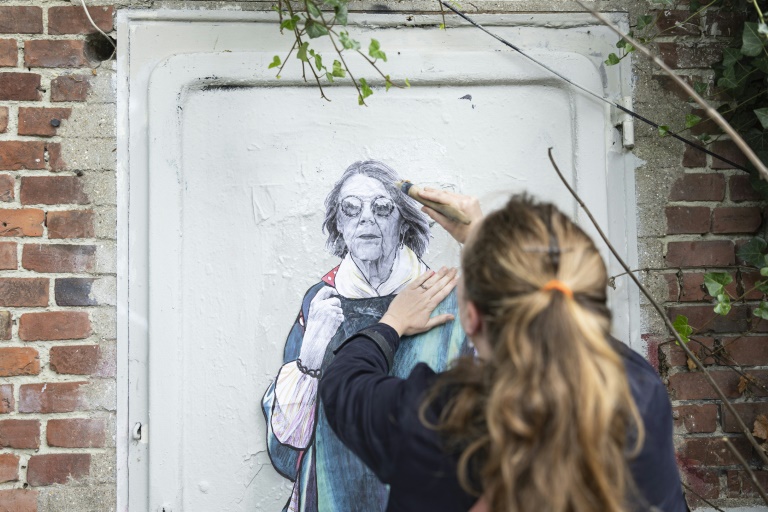 L'artiste de rue LaDame Quicolle installe un collage mural représentant Gisèle Pelicot, le 16 octobre 2024, à Lille