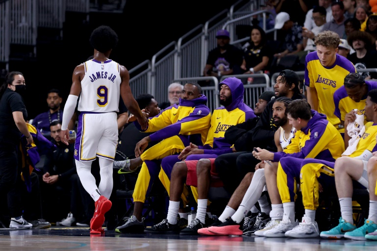 Bronny James (#9) tape dans la main de son père LeBron James et d'Anthony Davis, tous deux sur le banc, lors du dernier quart-temps du match de pré-saison contre les Phoenix Suns, le 6 octobre 2024 à Palm Springs