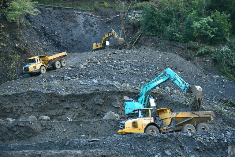 Des pelleteuses participent le 11 octobre aux travaux de reconstruction d'une portion de la RN 134 suite aux inondations à Urdos dans le sud-ouest de la France