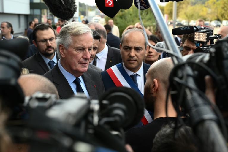 Le Premier ministre français Michel Barnier s'adresse à la presse lors de sa visite auprès des victimes des inondations, le 25 octobre 2024 à Givors (Rhône)