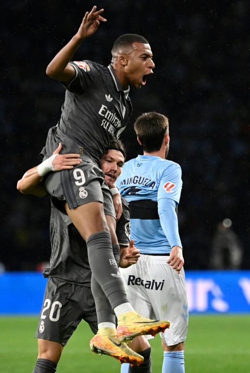 L'attaquant français du Real Madrid Kylian Mbappé (en haut) célèbre son ouverture du score, avec son coéquipier le défenseur espagnol Francisco Garcia, pendant le match de Liga espagnole face au RC Celta de Vigo au stade Balaidos à Vigo le 19 octobre 2024.