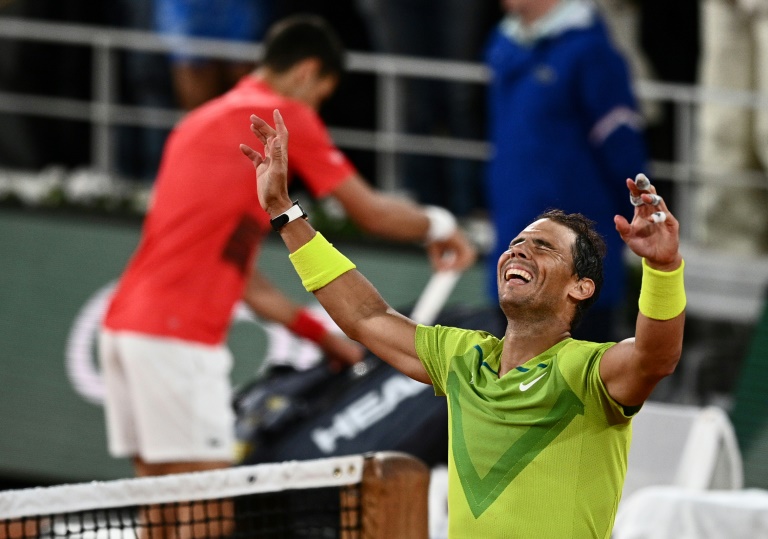 L'Espagnol Rafael Nadal (D) réagit après avoir gagné contre le Serbe Novak Djokovic (G) à la fin de leur match en quart de final de Roland-Garros Open, à Paris, 1er juin 2022