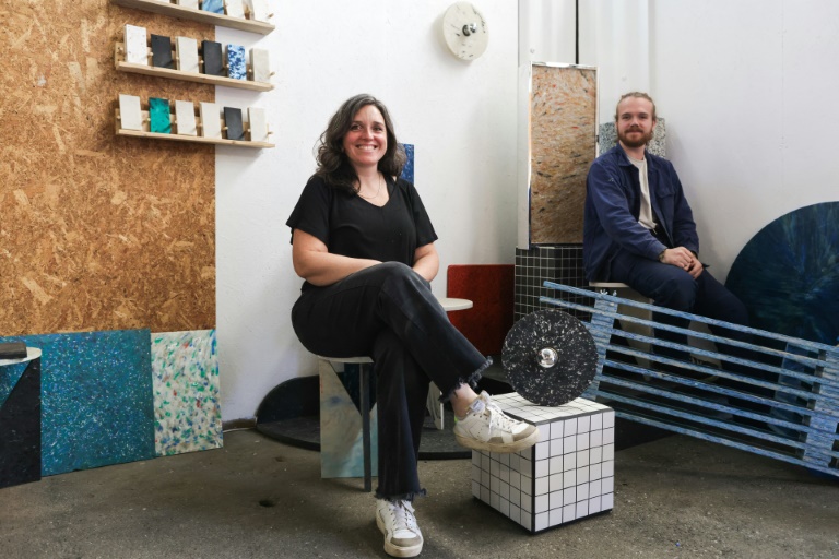 Julia Robert (G), co-fondatrice de l'association La Plastiquerie, et son apprenti Yoan Milin (D) devant leurs créations de mobilier design en plastique recyclé à Saint-Léon, près de Bordeaux, le 11 octobre 2024