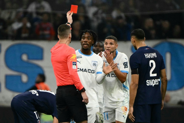 Le milieu marseillais Amine Harit reçoit un carton rouge par l'arbitre d'OM-PSG François Letexier (de dos), à Marseille, le 27 octobre 2024