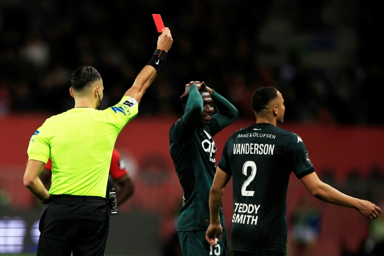 L'arbitre Jérémie Pignard (G) donne un carton rouge au défenseur  de Monaco Vanderson lors du derby de la Côte d'Azur entre l'OGC Nice et l'AS Monaco au stade Allianz Riviera, le 27 octobre 2024