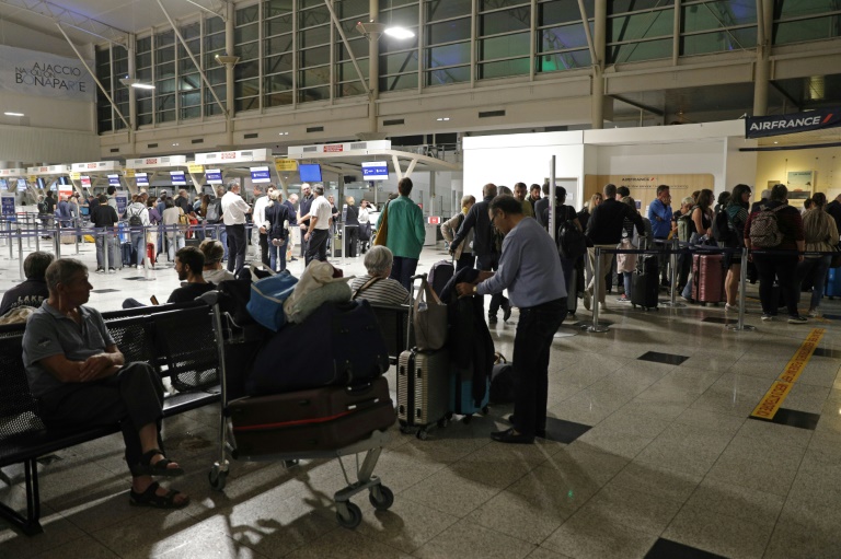 Des passagers attendent devant l'aéroport Napoléon Bonaparte d'Ajaccio, en Corse, le 3 octobre 2024