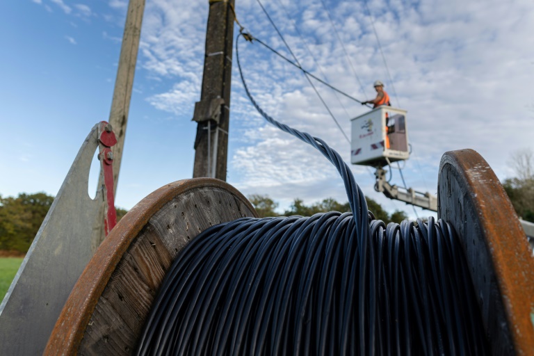 Des sous-traitants d'Enedis installent des câbles électriques triphasés isolés en remplacement d'anciens câbles nus à Brech, dans le Morbihan, le 28 octobre 2024