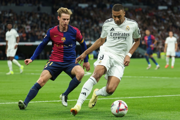 L'attaquant français du Real Madrid Kylian Mbappé (d.) devant le milieu de terrain néerlandais de Barcelone Frenkie De Jong (g.), à Madrid, le 26 octobre 2024