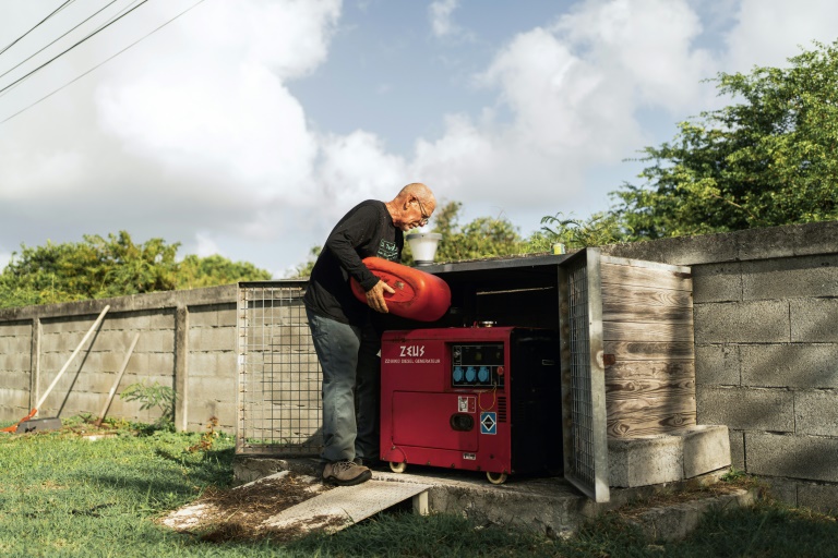 Un habitant remplit de carburant son générateur pendant une panne d'électricité, au Moule, en Guadeloupe le 26 octobre 2024