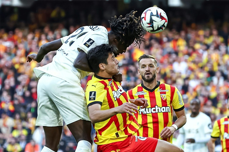 Le défensuer ouzbek de Lens, Abdukodir Khusanov (C) et de son coéquipier Jonathan Gradit (D) face à l'attaquant de Nice Evann Guessand lors du match entre le RC lens et l'OGC Nice, à Lens, le 28 septembre 2024