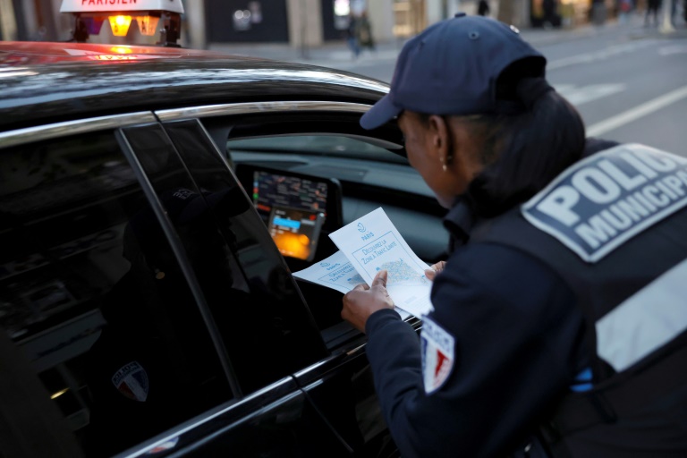 Une policière distribue des dépliants explicatifs sur les nouvelles zones à trafic limité (ZTL) à Paris, le 4 novembre 2024