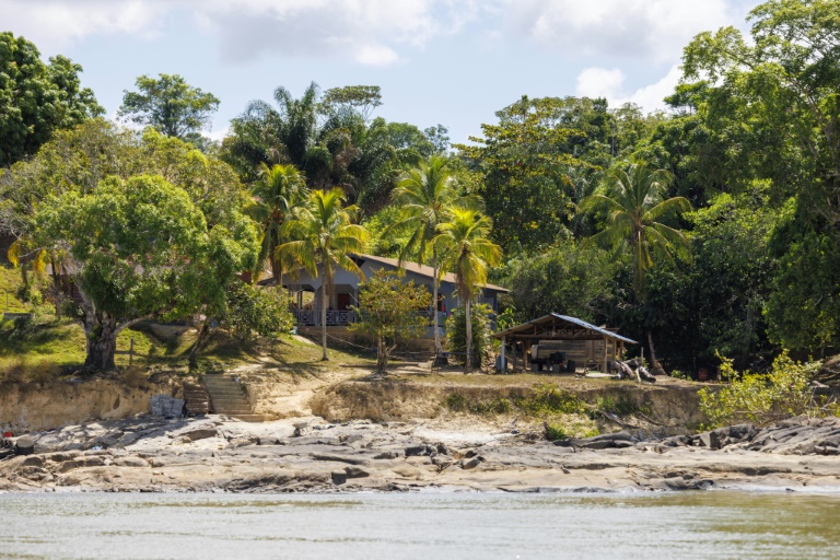 Une maison sur les rives du Maroni dont les rochers découverts permettent de constater l'abaissement du Maroni, près de la commune d'Apatou, le 6 novembre 2024