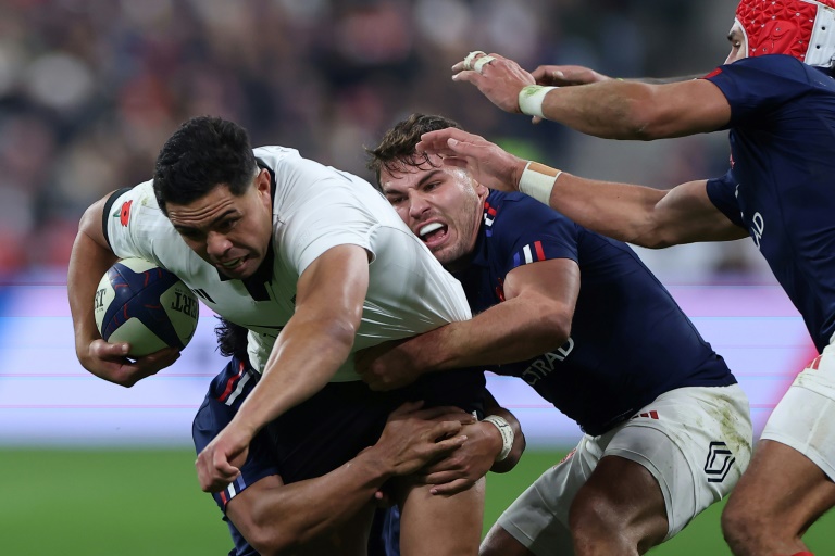 Le centre néo-zélandais Anton Lienert-Brown (gauche) est plaqué par le demi de mêlée et capitaine français Antoine Dupont (droite) lors du match-test d'automne entre la France et la Nouvelle-Zélande, le 16 novembre 2024