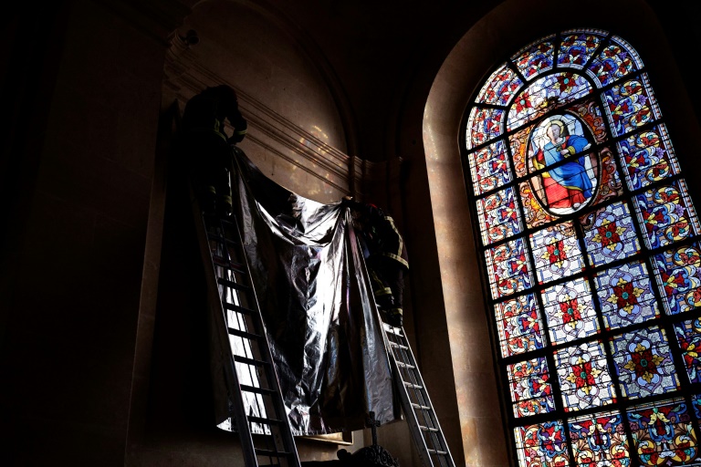 Des pompiers couvrent un tableau lors un exercice d'incendie grandeur nature à la cathédrale Saint-Louis de Versailles, le 20 novembre 202